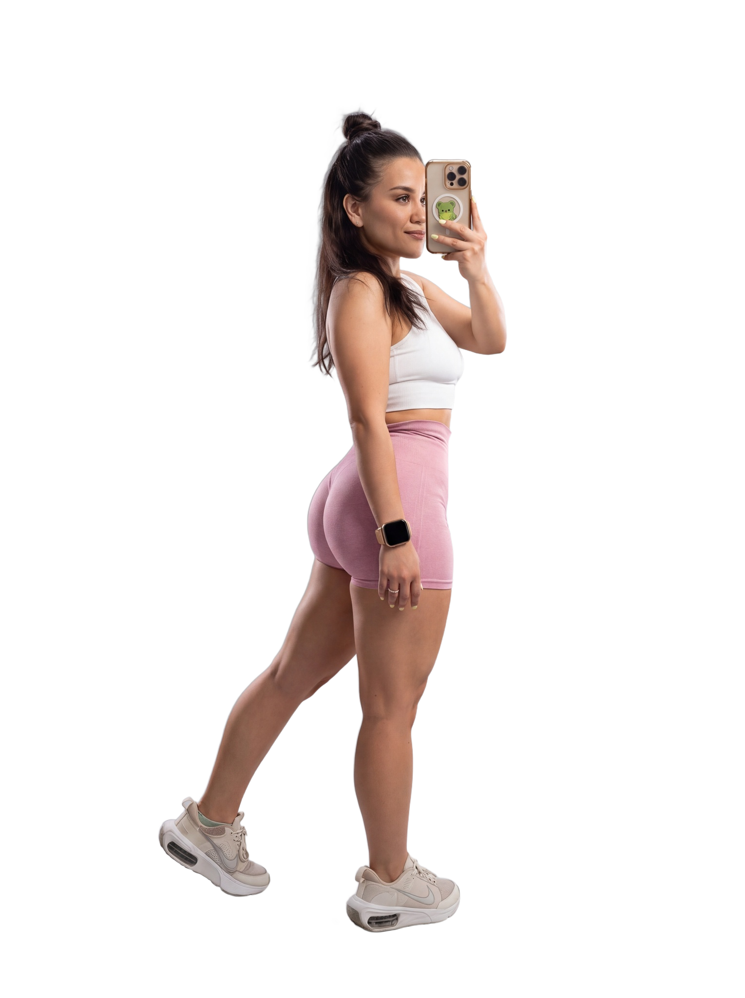 Full-length mirror portrait in a white top, pink shorts and sneakers